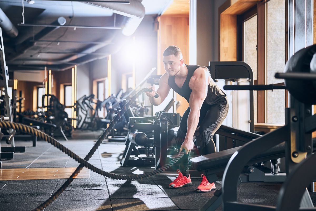 A man doing Battle Rope, one of the cardio exercises you can do at the gym