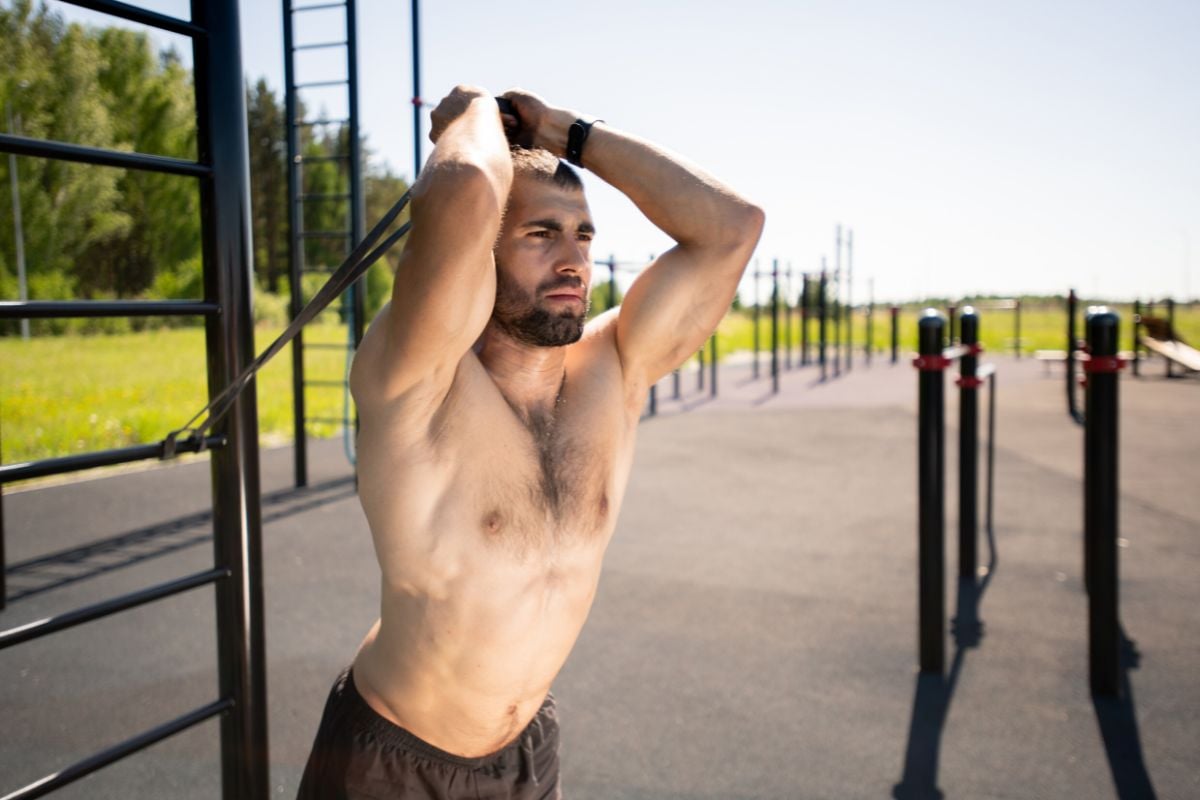 A man doing Resistance Band Overhead Triceps Extension