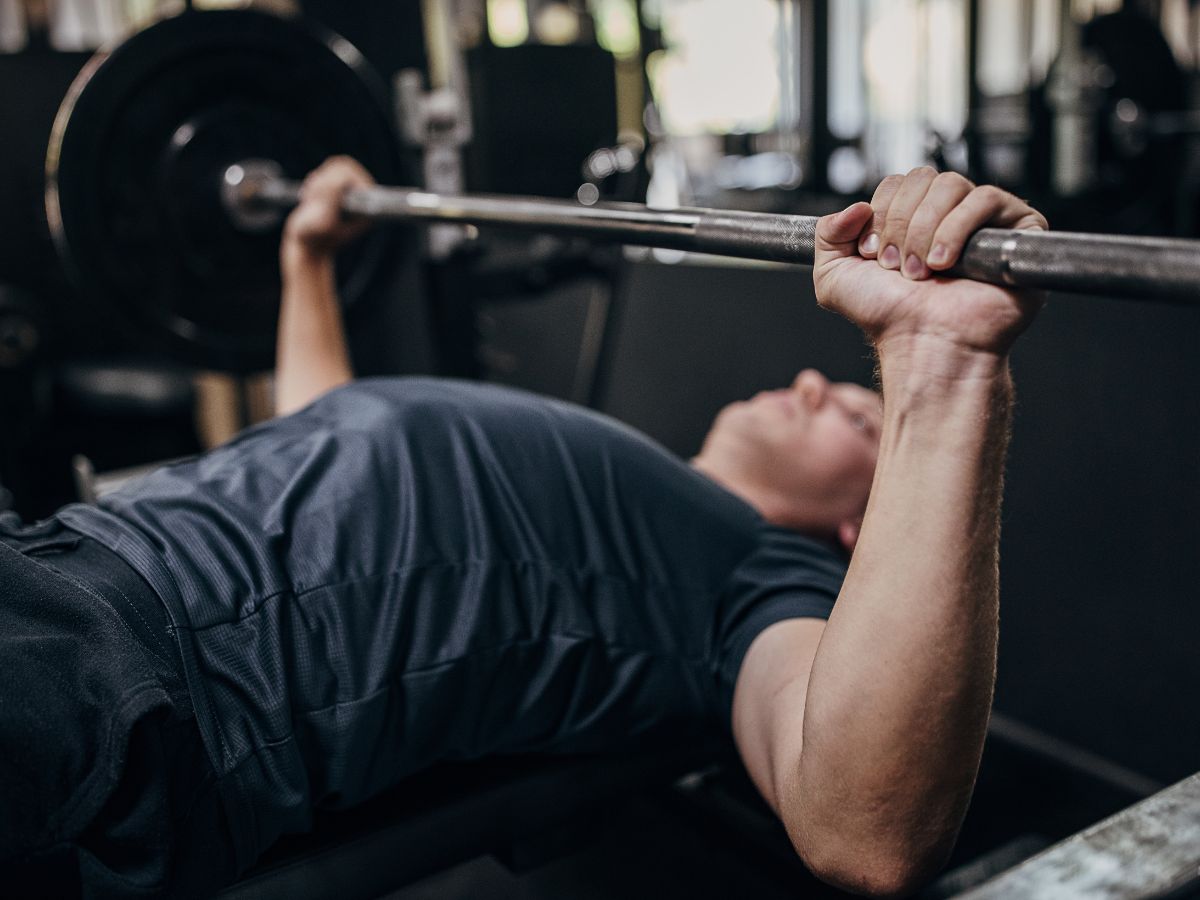 2 Day Gym Workout Plans to Get Strong and Athletic w/ PDF A man is working out to build pure strength